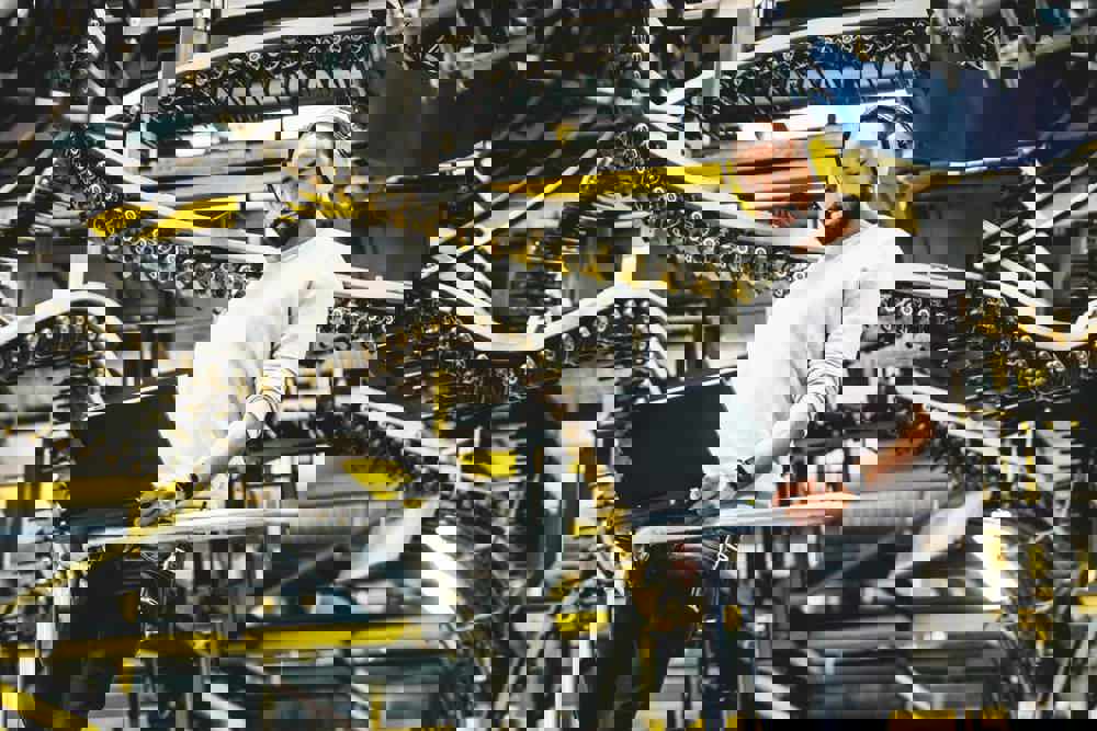 Print Factory Engineer Working Alongside Moving Machinery (1)