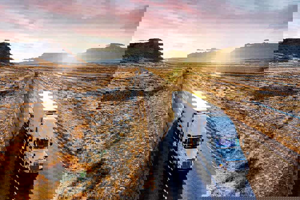 White Semi-Trailer Truck Heading down a four-lane Highway at Dusk