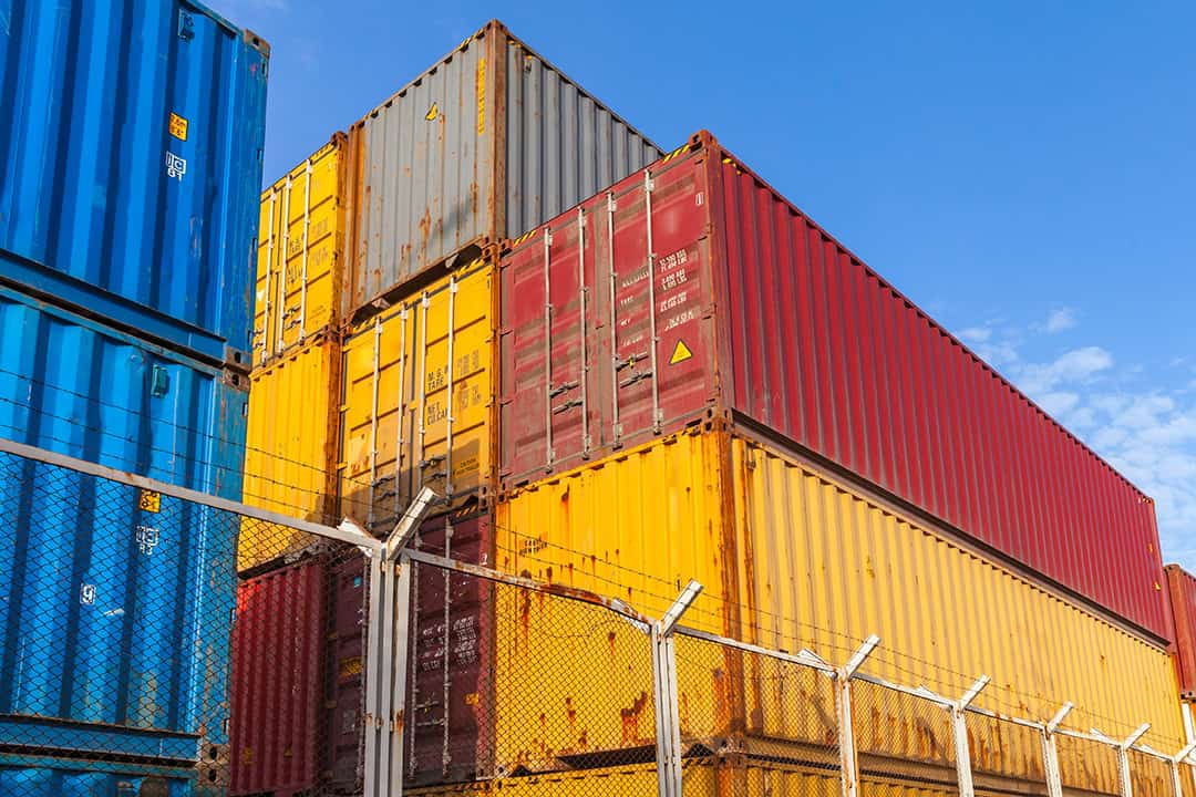 Colorful Cargo Containers Are Stacked Behind Metal Fence