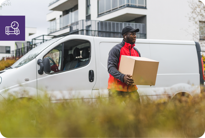 blue-collar worker - package delivery person - in front of white truck with cardboard package.