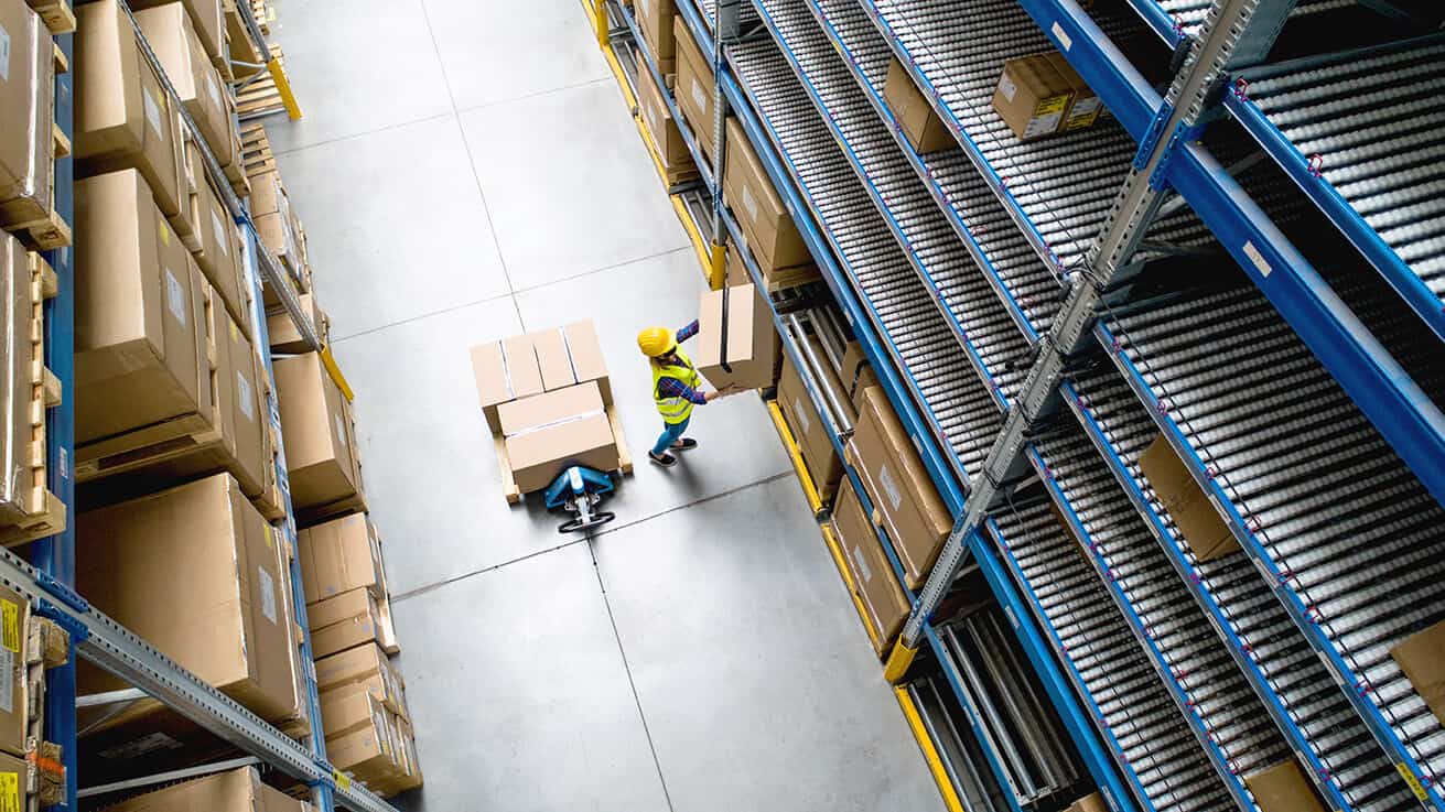 Aerial view of woman worker with face mask working in warehouse.