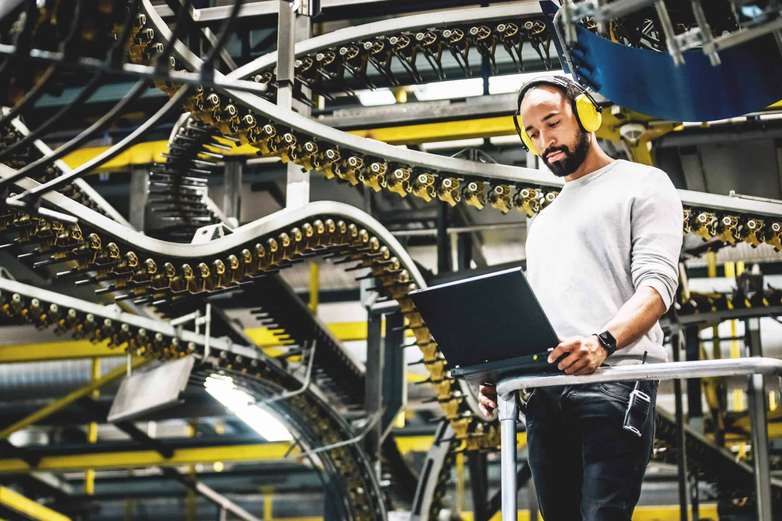 Print Factory Engineer Working Alongside Moving Machinery