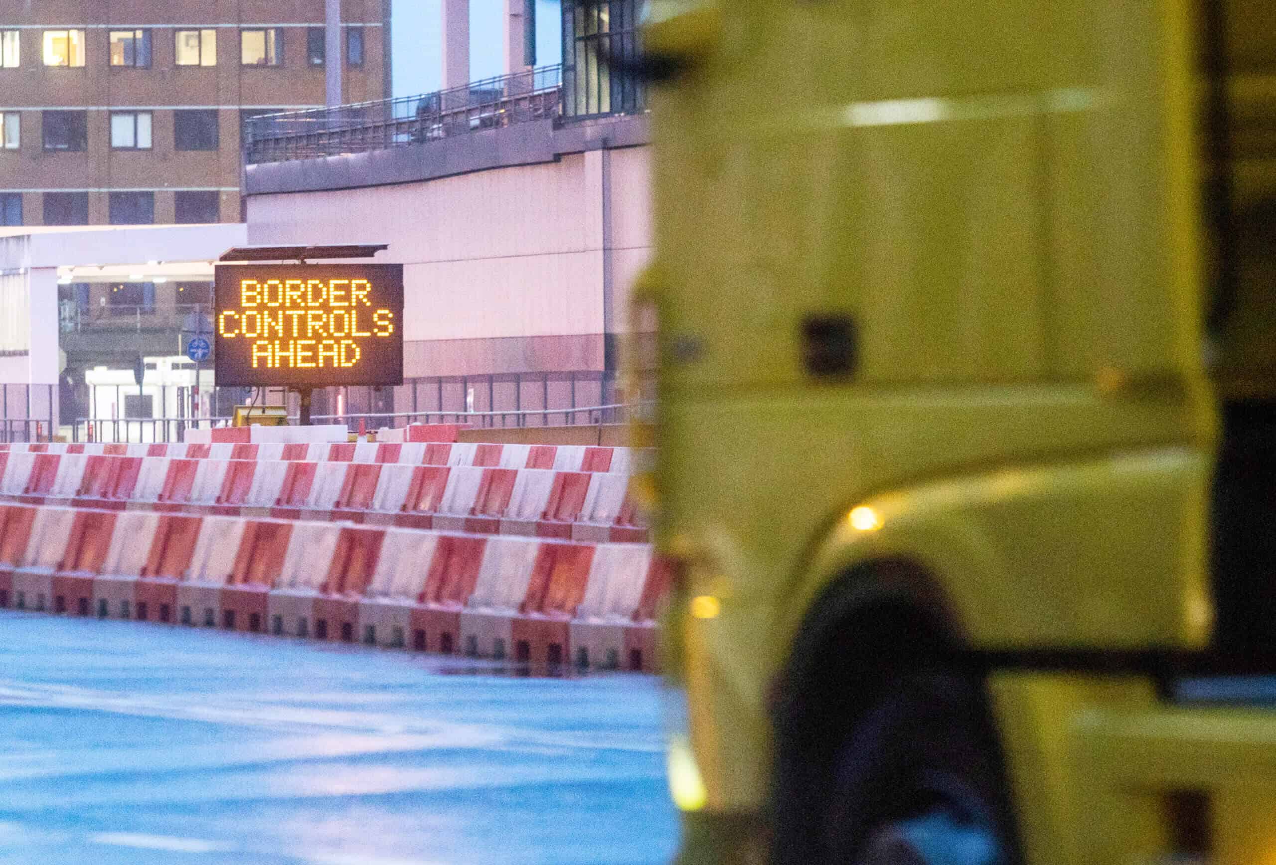 A truck approaches a border control sign.