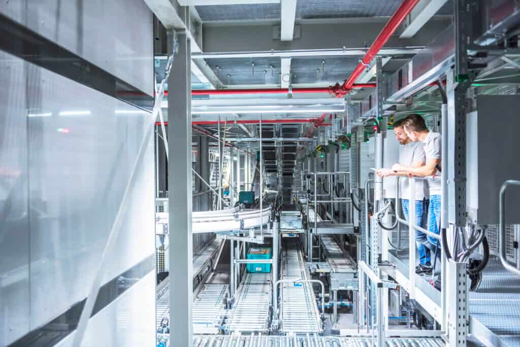 Two men talking in automatized high rack warehouse Two men talking in automatized high rack warehouse