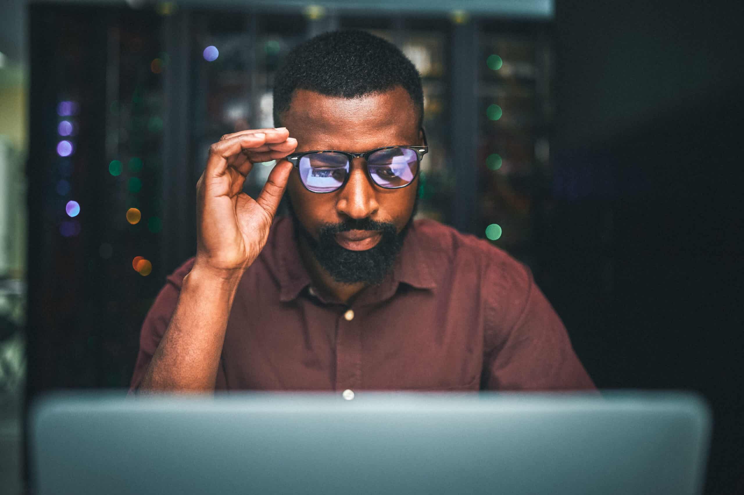 Shot of an male IT technician in a server room and using a laptop