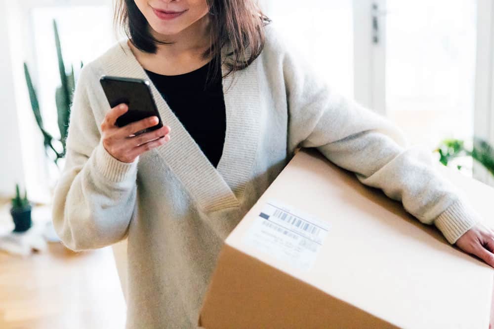 Smiling woman receiving parcel at home