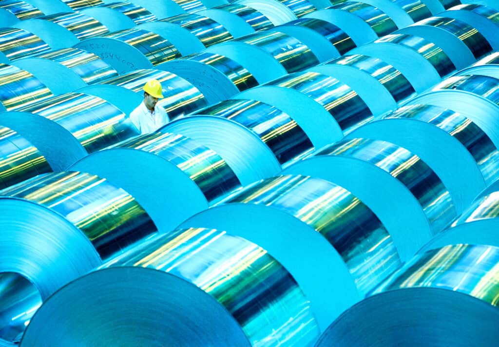 Male worker with helmet inspects stock aluminum reels