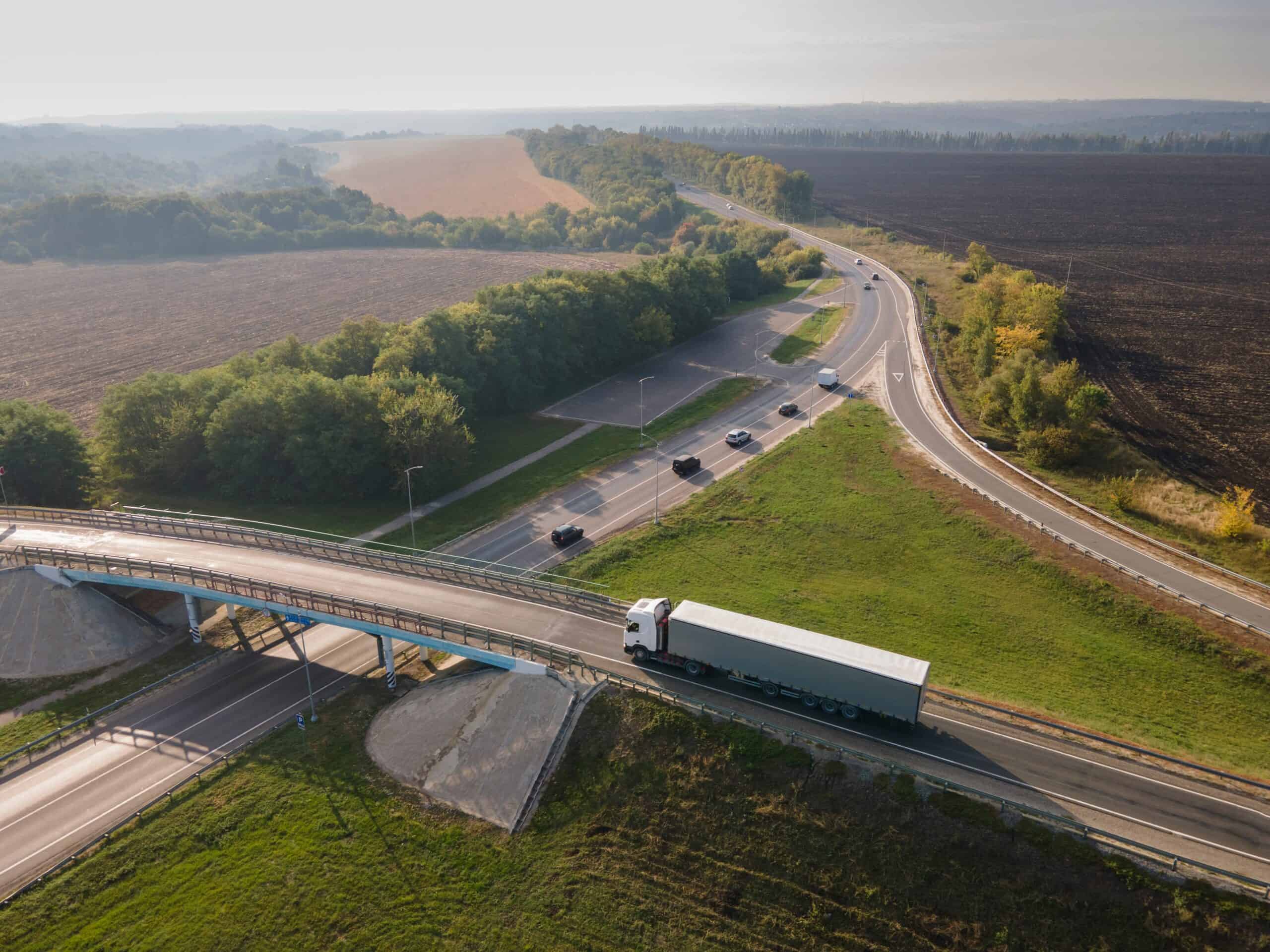 Truck,with,cargo,semi,trailer,moving,on,road,in,direction.