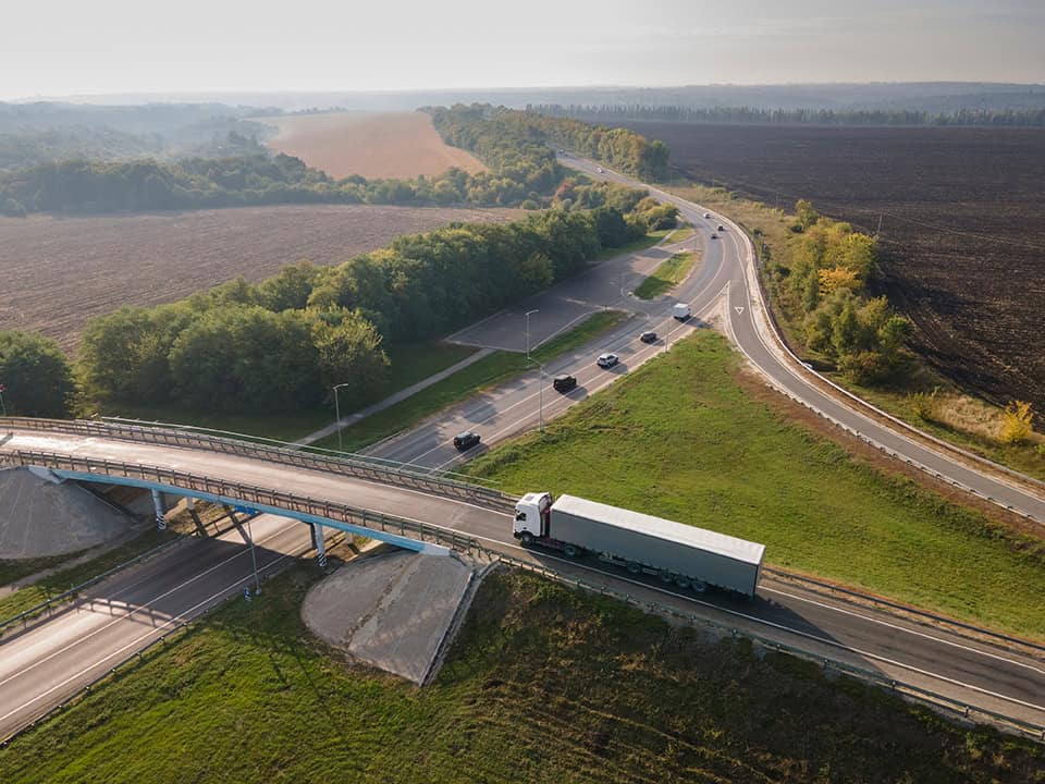 Truck,with,cargo,semi,trailer,moving,on,road,in,direction.