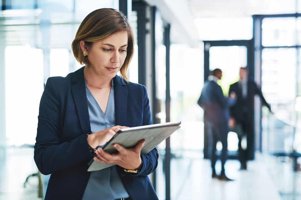 Smart Technology Has You Covered. An Attractive Young Businesswoman Using A Digital Tablet In An Office With Her Colleagues In The Background. Smart Technology Has You Covered. An Attractive Young Businesswoman Using A Digital Tablet In An Office With Her Colleagues In The Background.