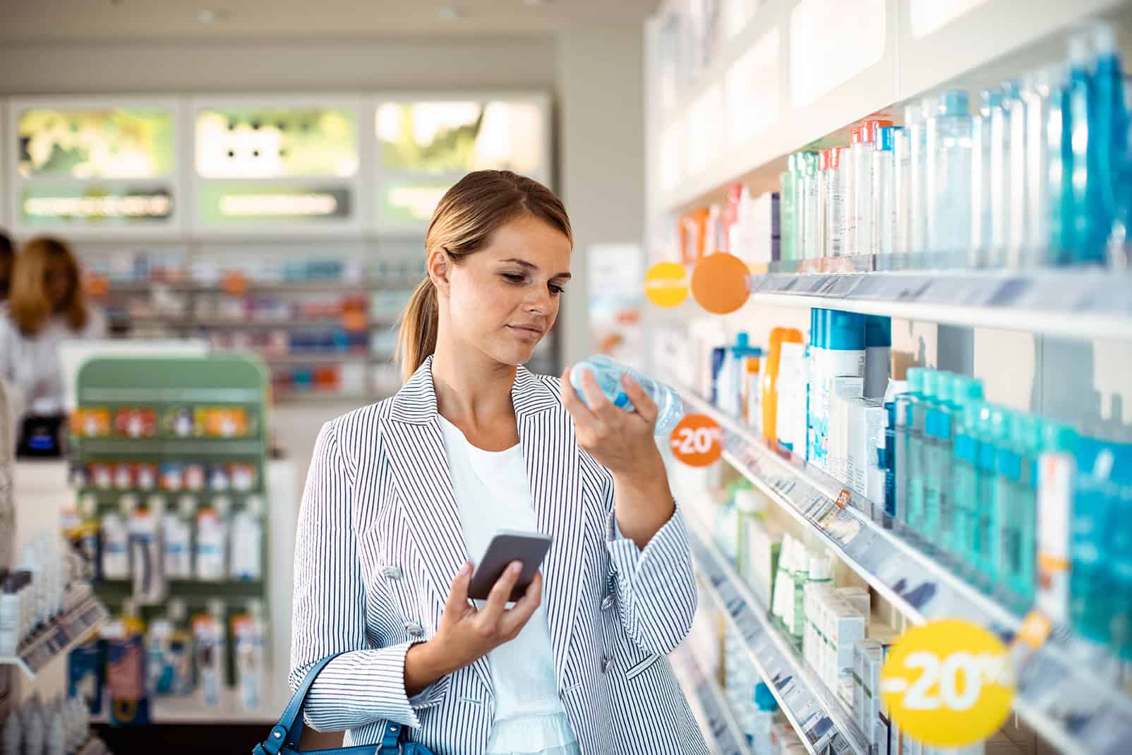 Young,woman,reading,product,label,in,pharmacy